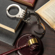 Handcuff with gavel and law books - justice theme.