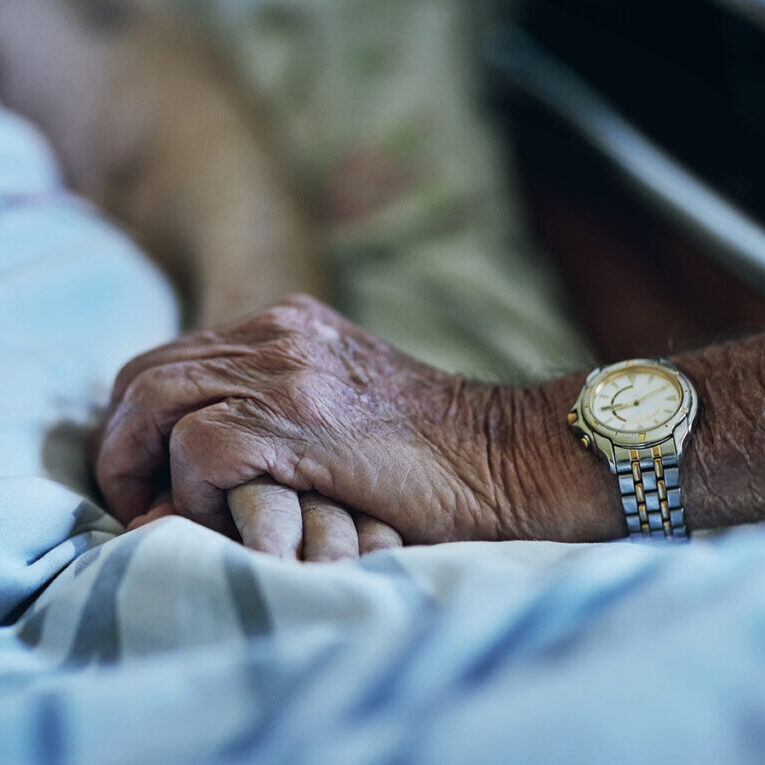 Senior people, hands and visit with hospital, closeup and elderly care or love together. Elderly person, couple and relationship with medical checkup, help and empathy for surgery recovery and health.