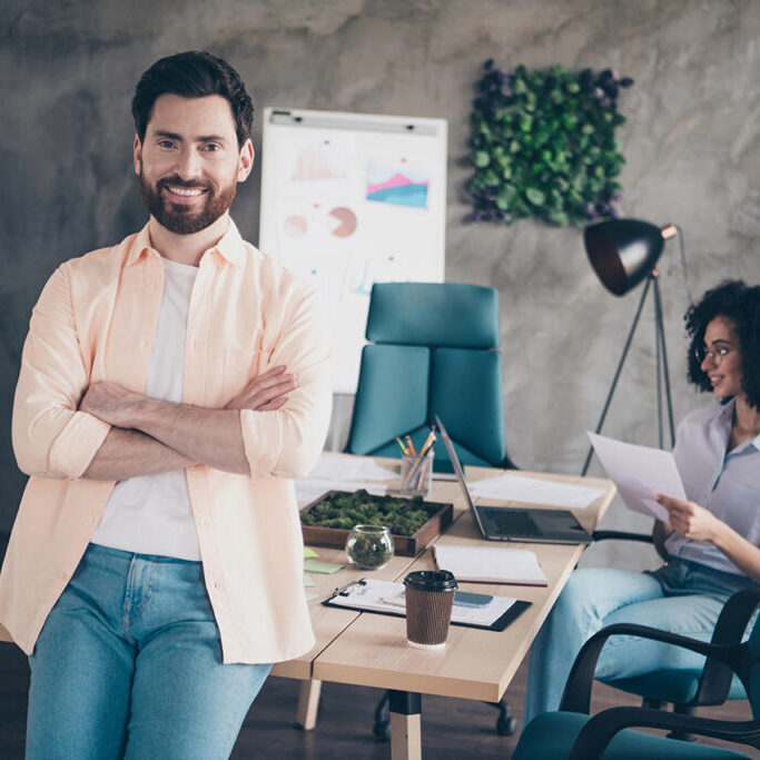 Portrait of two young corporate workers collaborate modern loft interior office indoors.