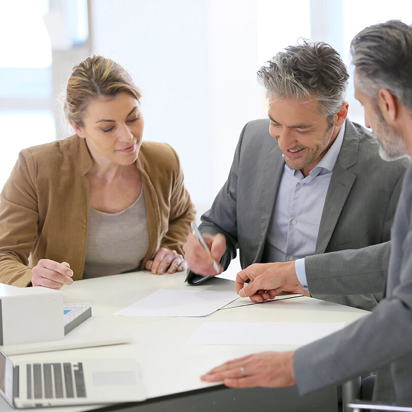 Mature couple signing construction contract in architect's office